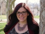 Danielle standing next to a tree smiling at the camera